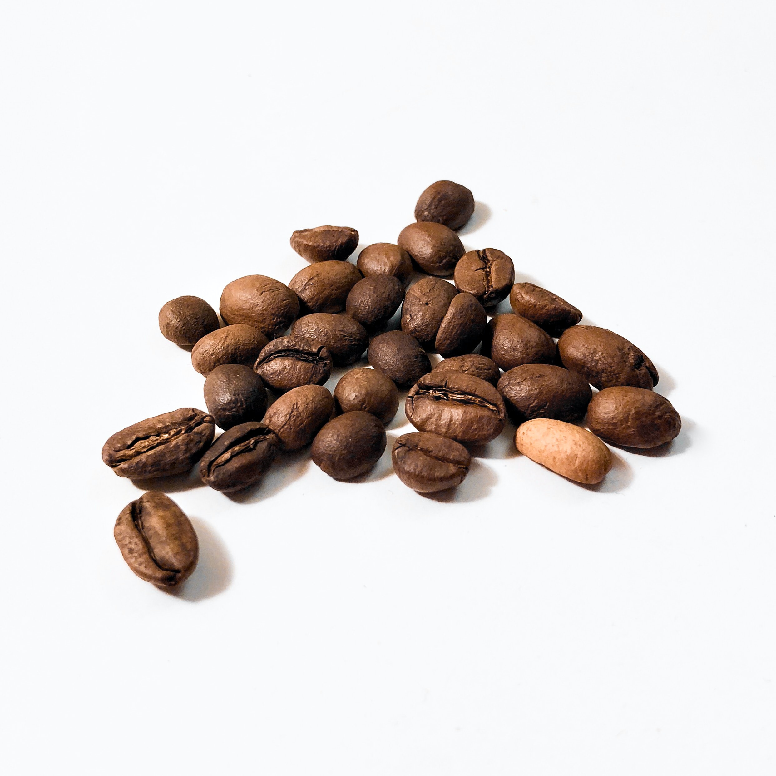 A close-up of coffee beans on a white background