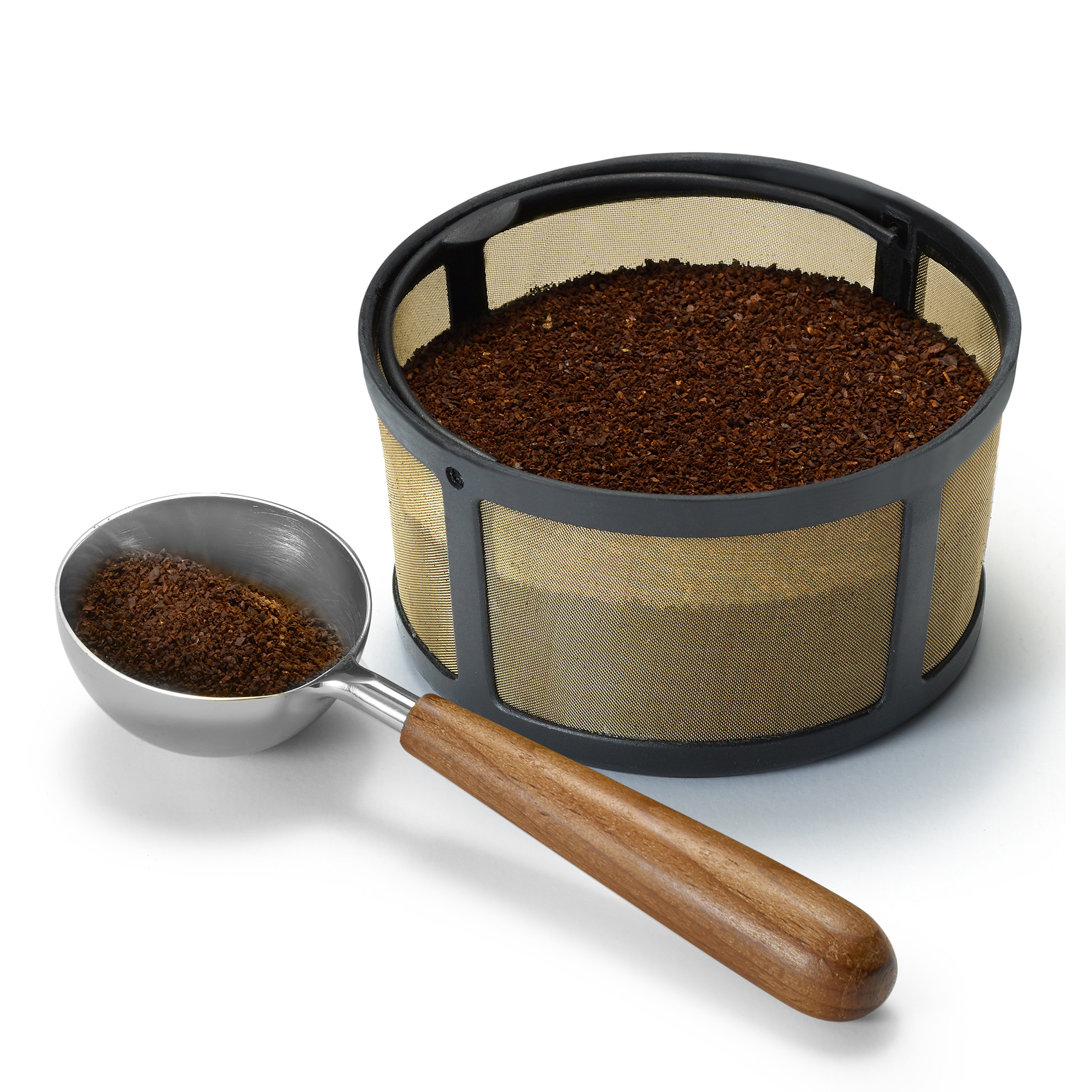 Ground coffee in a reusable filter with a wooden spoon next to it with some ground coffee in.